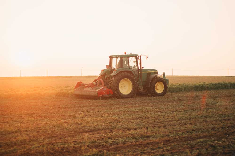Tractor on farm at sunset