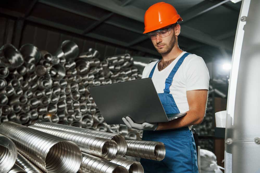 Industrial worker with computer at factory floor
