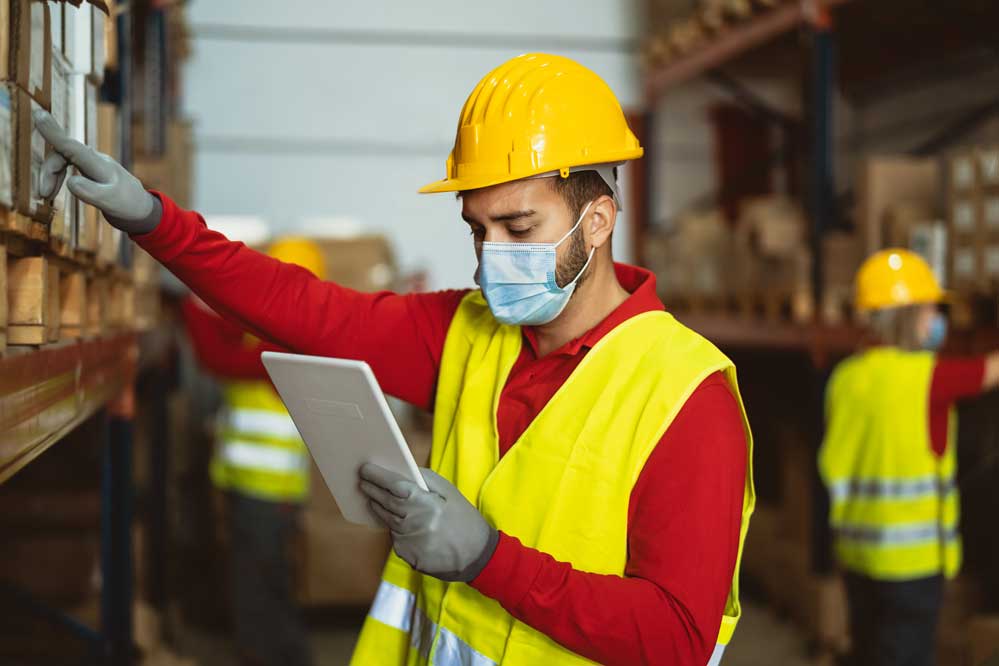 Worker with tablet at industrial manufacturing facility