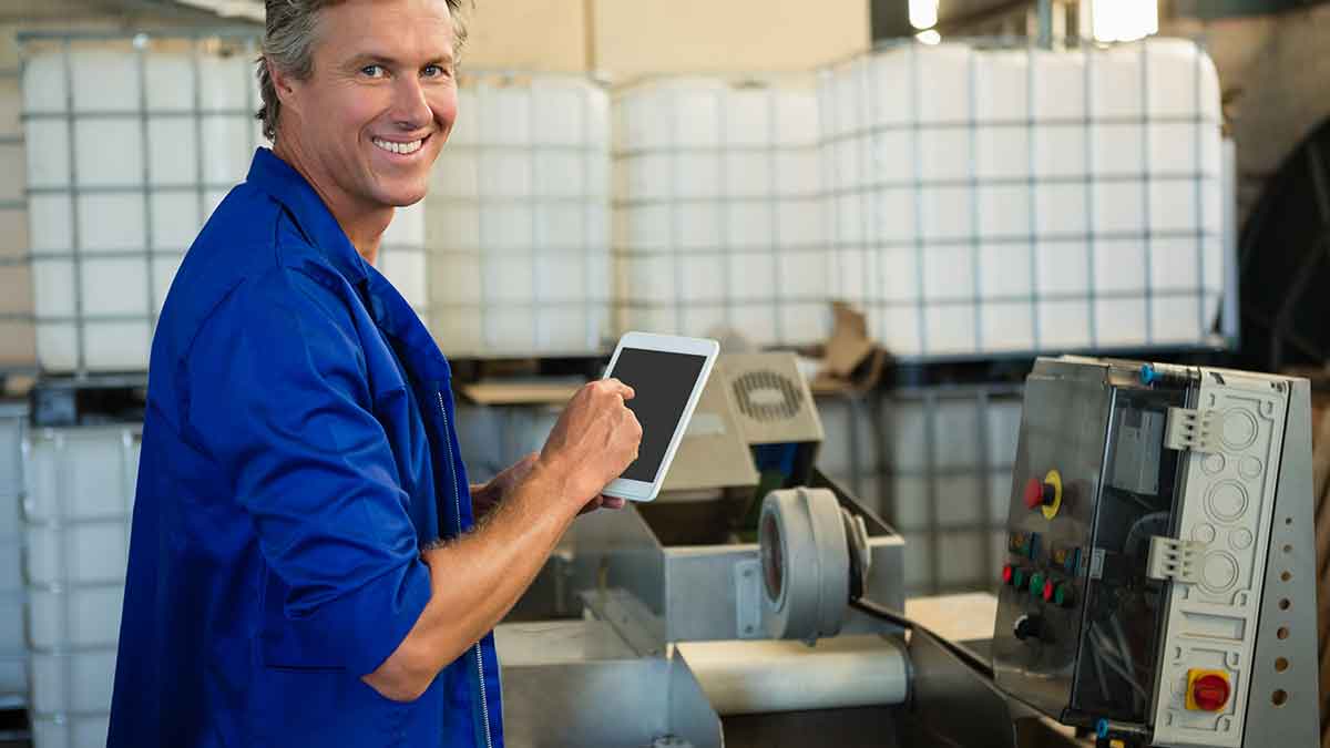 smiling worker taking full advantage of the fourth industrial revolution to improve production operations